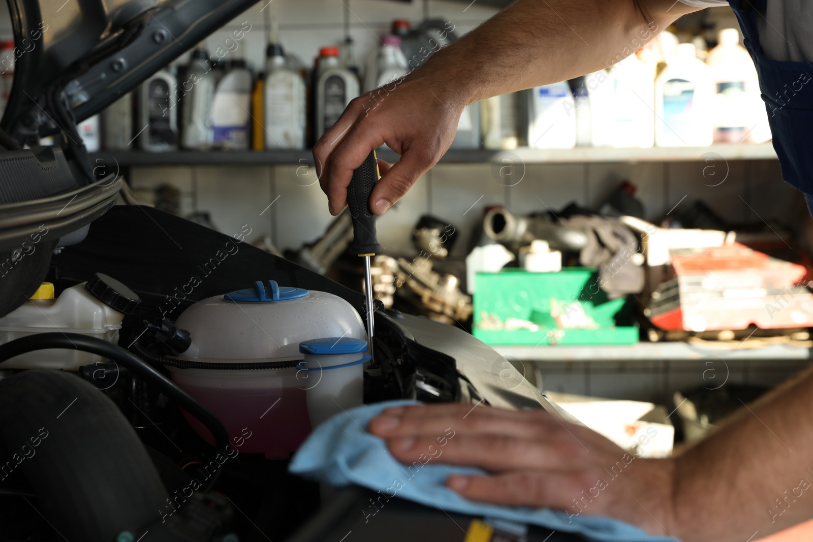 Photo of Professional auto mechanic fixing modern car in service center, closeup