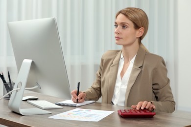 Professional accountant working at wooden desk in office