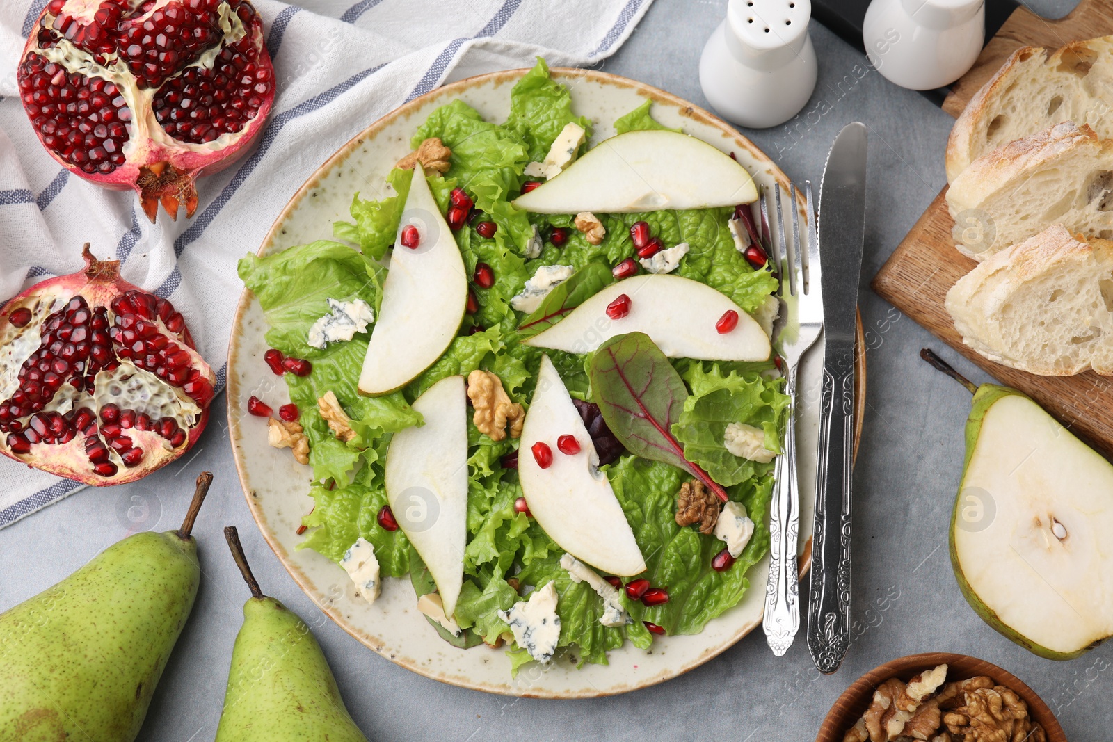 Photo of Delicious pear salad served on grey textured table, flat lay