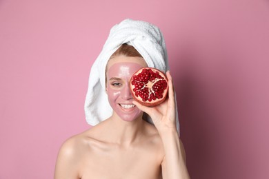Young woman with pomegranate face mask and fresh fruit on pink background