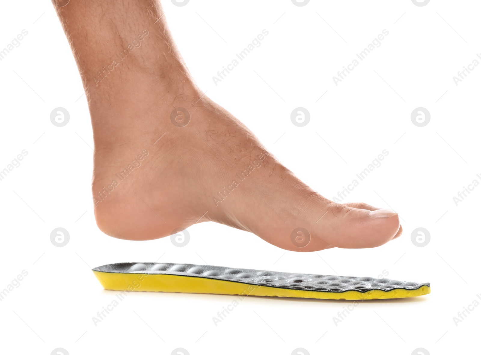 Photo of Man fitting orthopedic insole on white background, closeup. Foot care