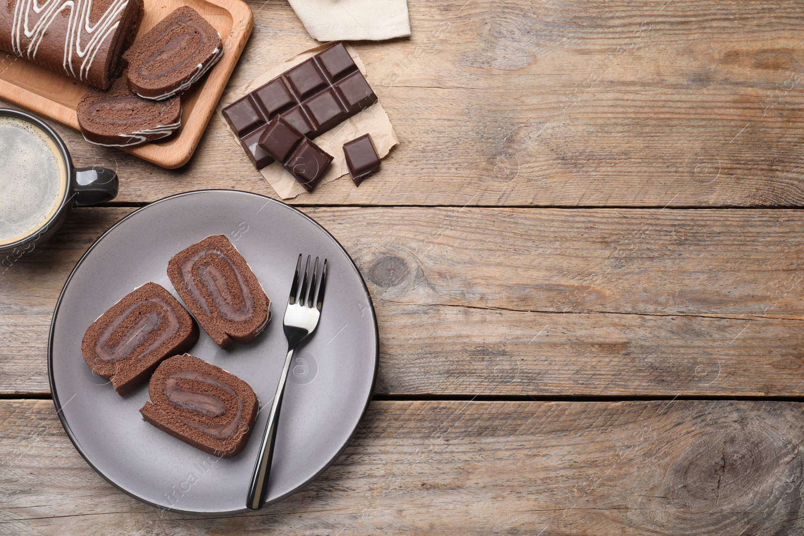 Photo of Tasty chocolate cake roll with cream on wooden table, flat lay. Space for text