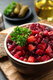 Photo of Traditional Russian salad vinaigrette on wooden board, closeup