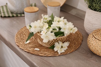 Beautiful jasmine flowers on wooden table indoors