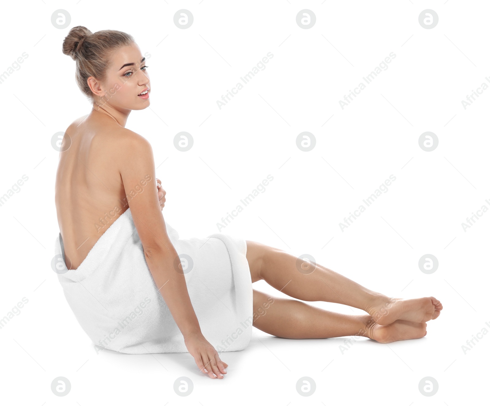 Photo of Young woman with soft towel sitting on white background