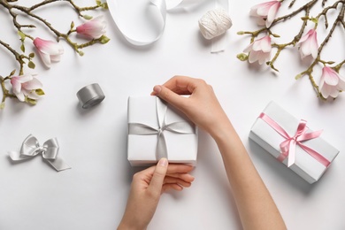 Woman with beautiful gift boxes on white background, top view