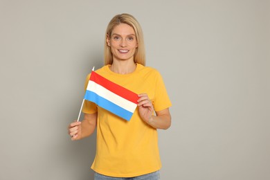 Photo of Woman with flag of Netherlands on light grey background