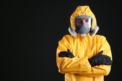 Photo of Man wearing chemical protective suit on black background, space for text. Virus research