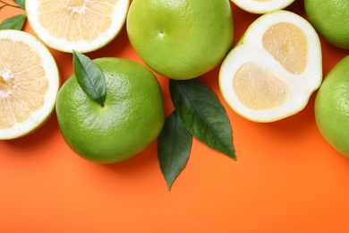 Photo of Fresh ripe sweeties and green leaves on orange background, flat lay