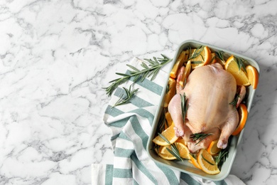 Photo of Flat lay composition with chicken, orange slices, rosemary and kitchen towel on white marble table