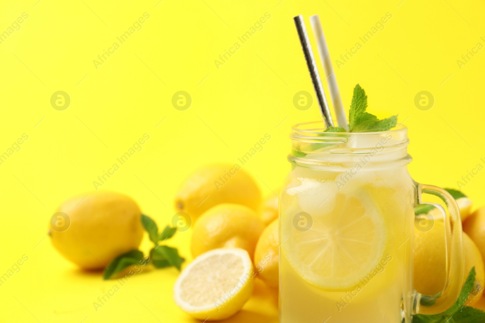 Photo of Natural freshly made lemonade with mint on yellow background, closeup. Summer refreshing drink