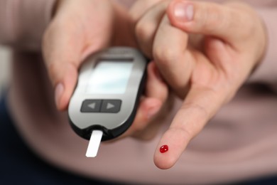 Diabetes test. Man checking blood sugar level with glucometer, closeup