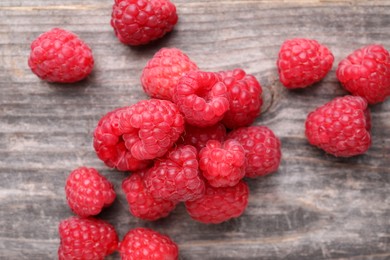 Photo of Tasty ripe raspberries on wooden table, top view