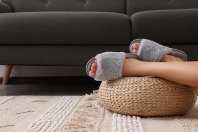 Photo of Woman wearing grey soft slippers in room, closeup. Space for text