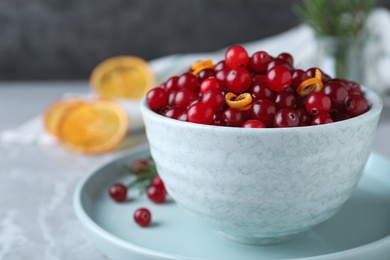 Fresh ripe cranberries on grey table, closeup. Space for text