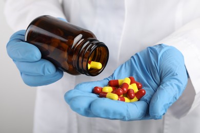 Photo of Woman holding many antibiotic pills and bottle, closeup. Medicinal treatment