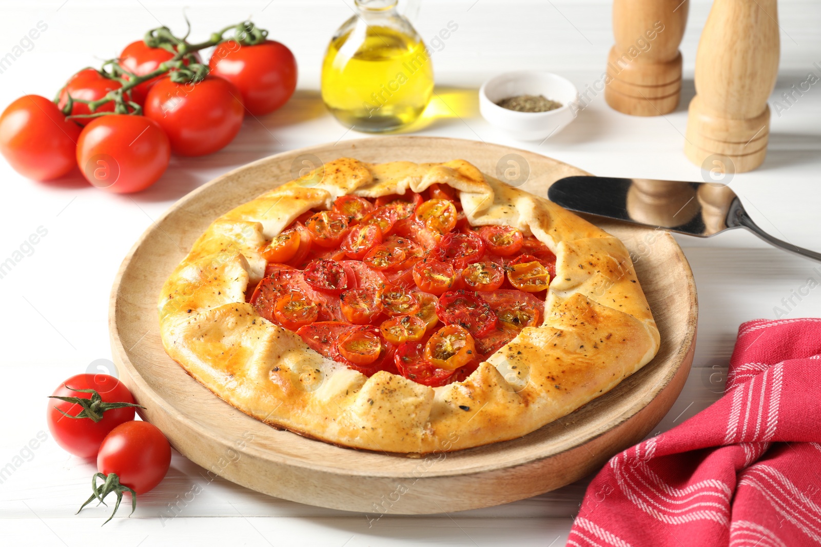 Photo of Tasty tomato galette (Caprese galette) on white wooden table, closeup