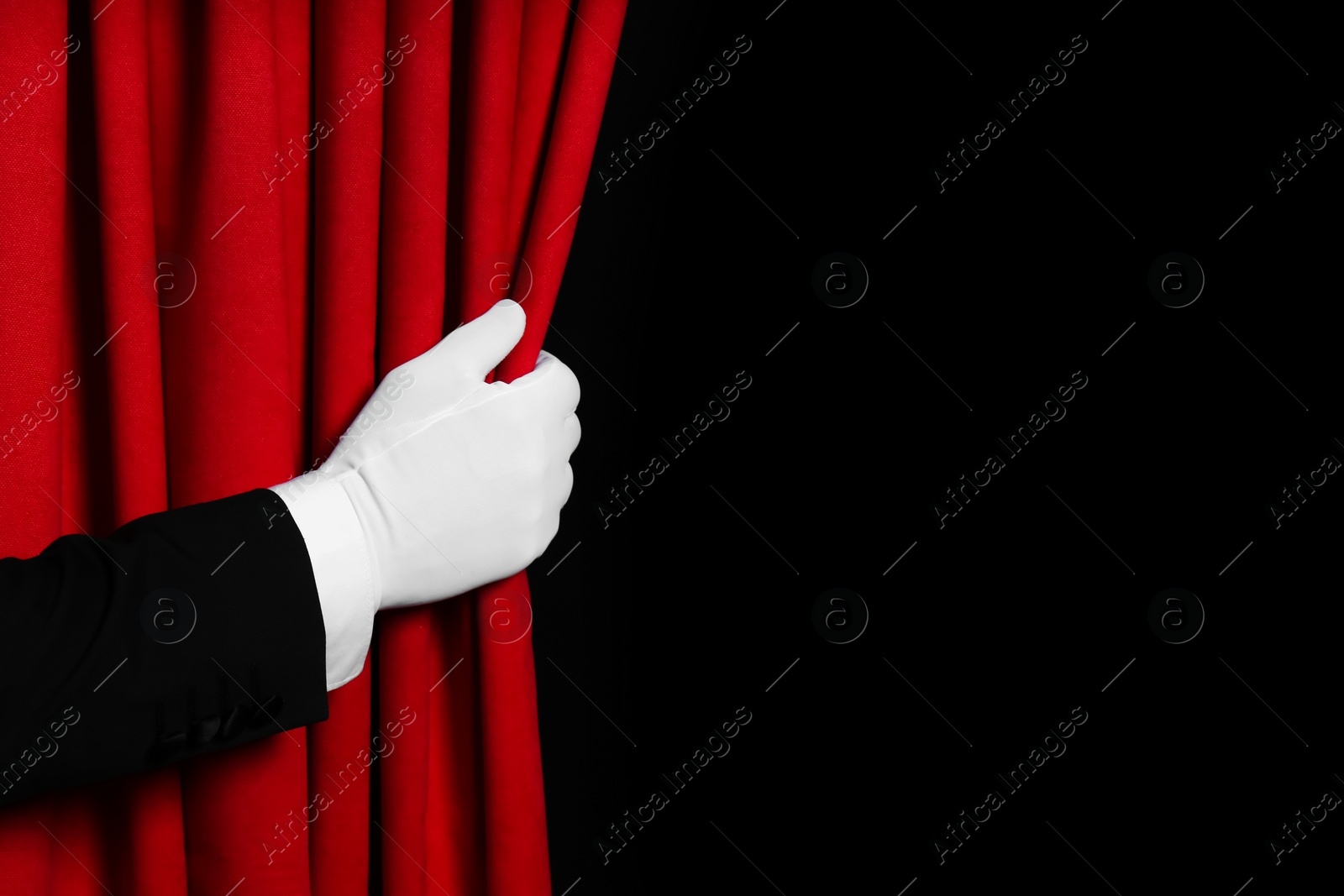 Photo of Person opening red front curtains on black background, closeup. Space for text