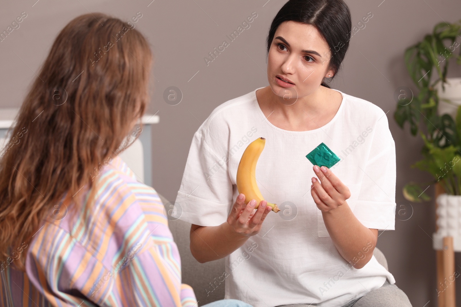 Photo of Mother talking with her teenage daughter about contraception at home. Sex education concept