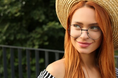 Photo of Portrait of beautiful woman in glasses outdoors. Space for text