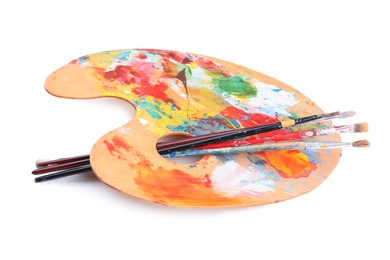 Photo of Palette with paints and brushes on white background. Artist equipment