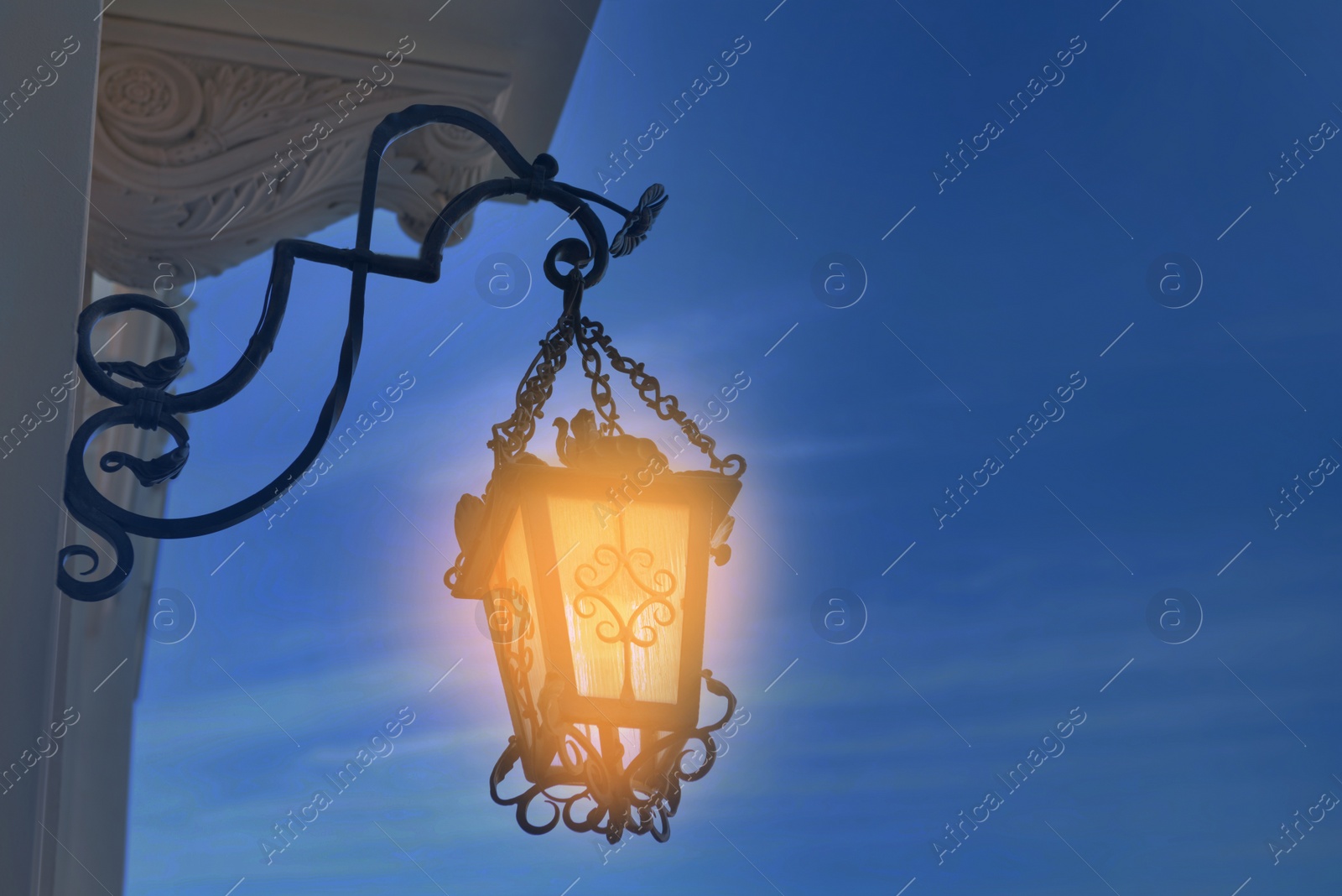 Image of Beautiful old fashioned street lamp lighting on wall of building