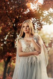 Beautiful girl wearing fairy dress in autumn forest