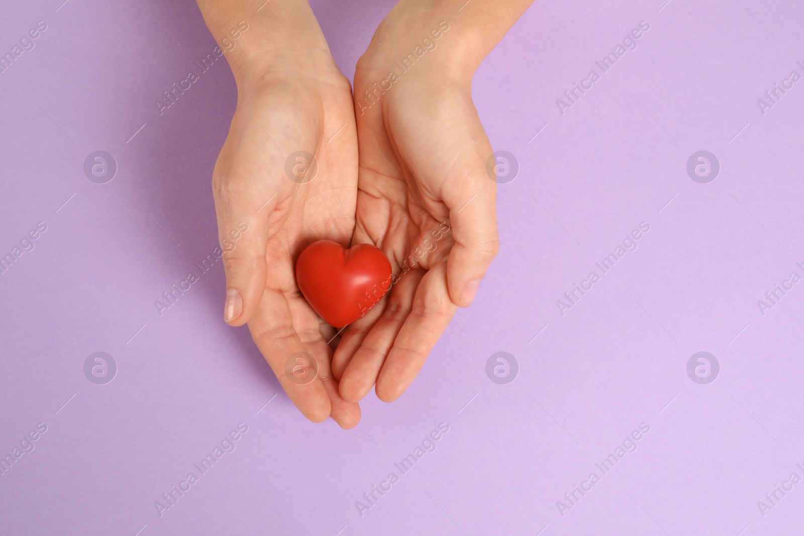 Photo of Woman holding decorative heart on color background, top view with space for text
