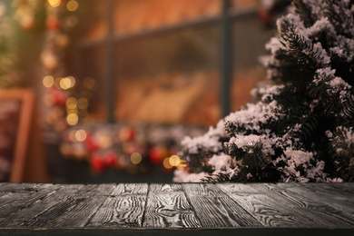Image of Empty wooden surface and fir branches covered with snow on blurred background. Christmas time