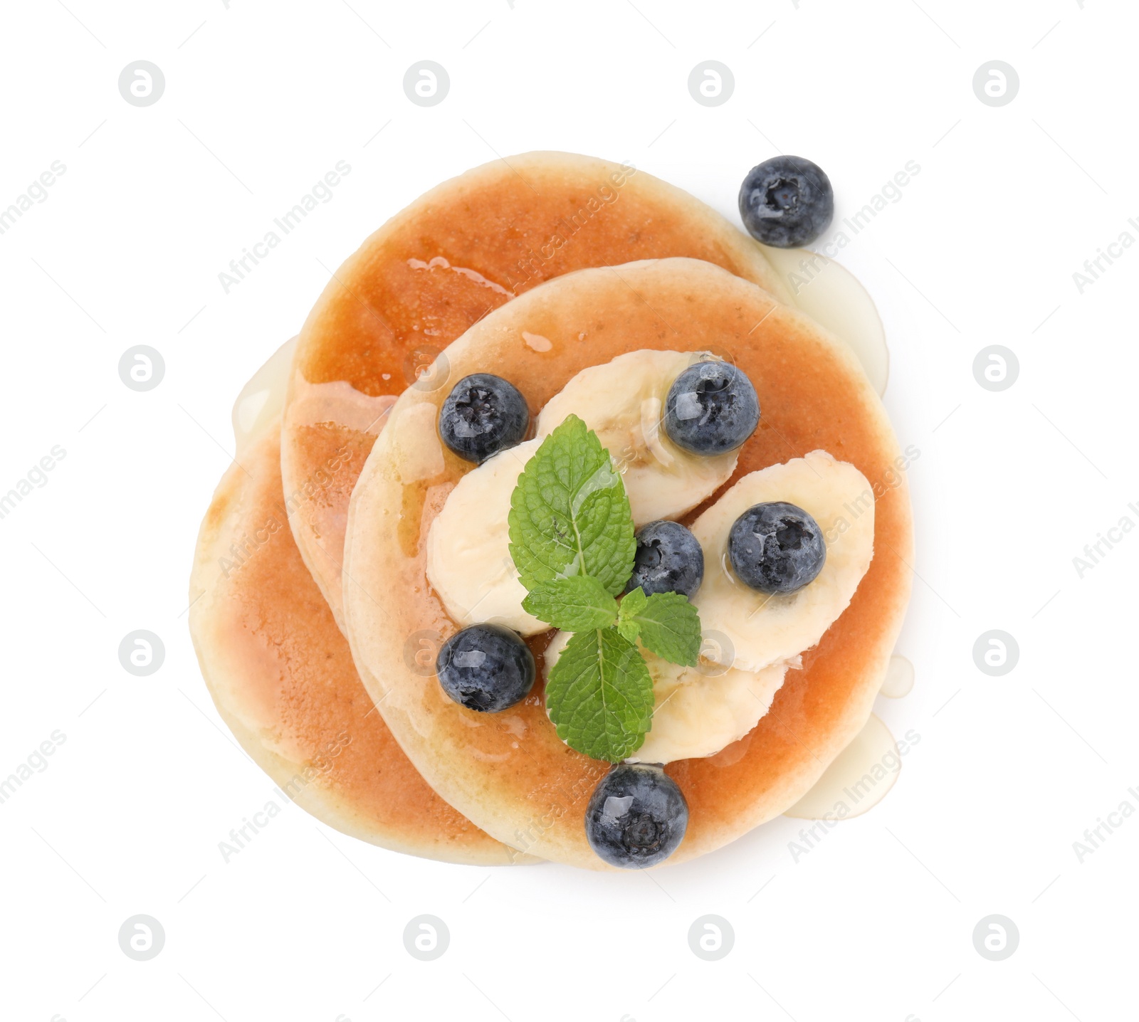 Photo of Delicious pancakes with banana slices, blueberries and mint isolated on white, top view