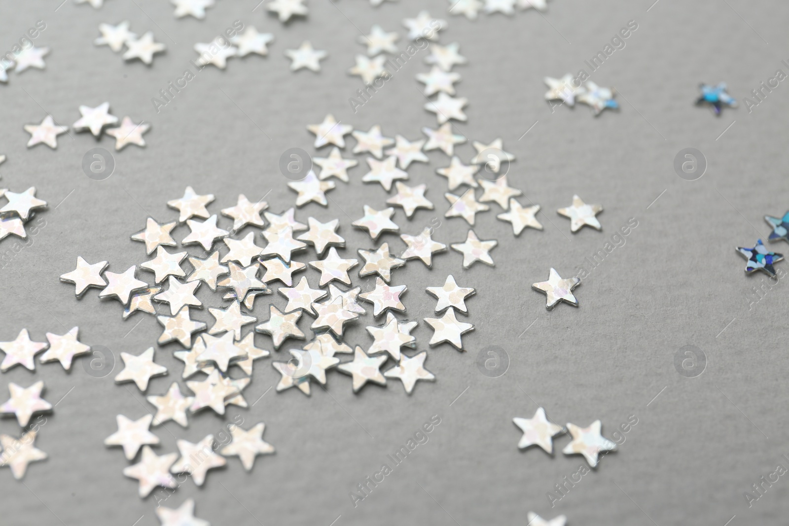 Photo of Confetti stars on grey background, closeup. Christmas celebration