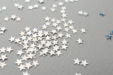 Photo of Confetti stars on grey background, closeup. Christmas celebration