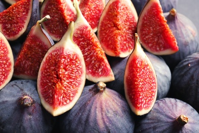 Fresh ripe fig slices as background. Tropical fruit