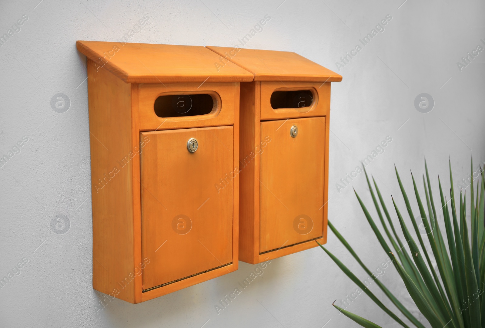 Photo of Orange wooden letter boxes on white wall