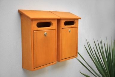 Orange wooden letter boxes on white wall