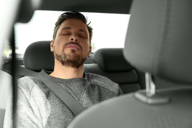 Tired handsome man sleeping in his modern car