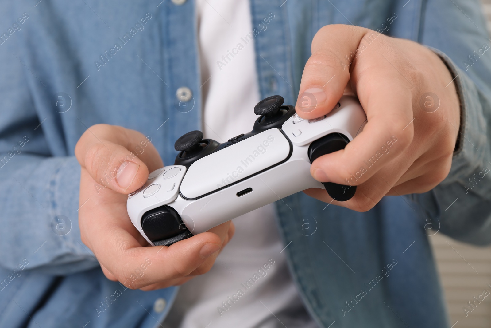 Photo of Man using wireless game controller indoors, closeup