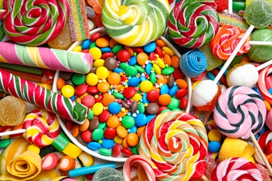 Many different yummy candies as background, top view