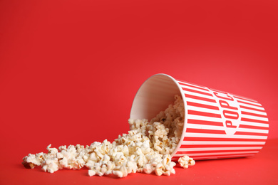 Photo of Tasty fresh pop corn on red background