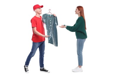 Dry-cleaning delivery. Courier giving dress in plastic bag to woman on white background