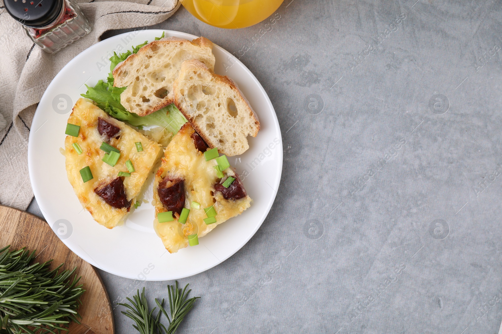 Photo of Tasty sausage casserole served on grey table, flat lay. Space for text