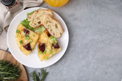 Photo of Tasty sausage casserole served on grey table, flat lay. Space for text