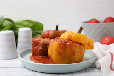 Photo of Delicious stuffed bell peppers on white wooden table