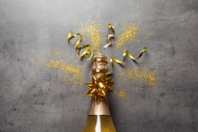 Photo of Flat lay composition with bottle of champagne for celebration on grey stone background