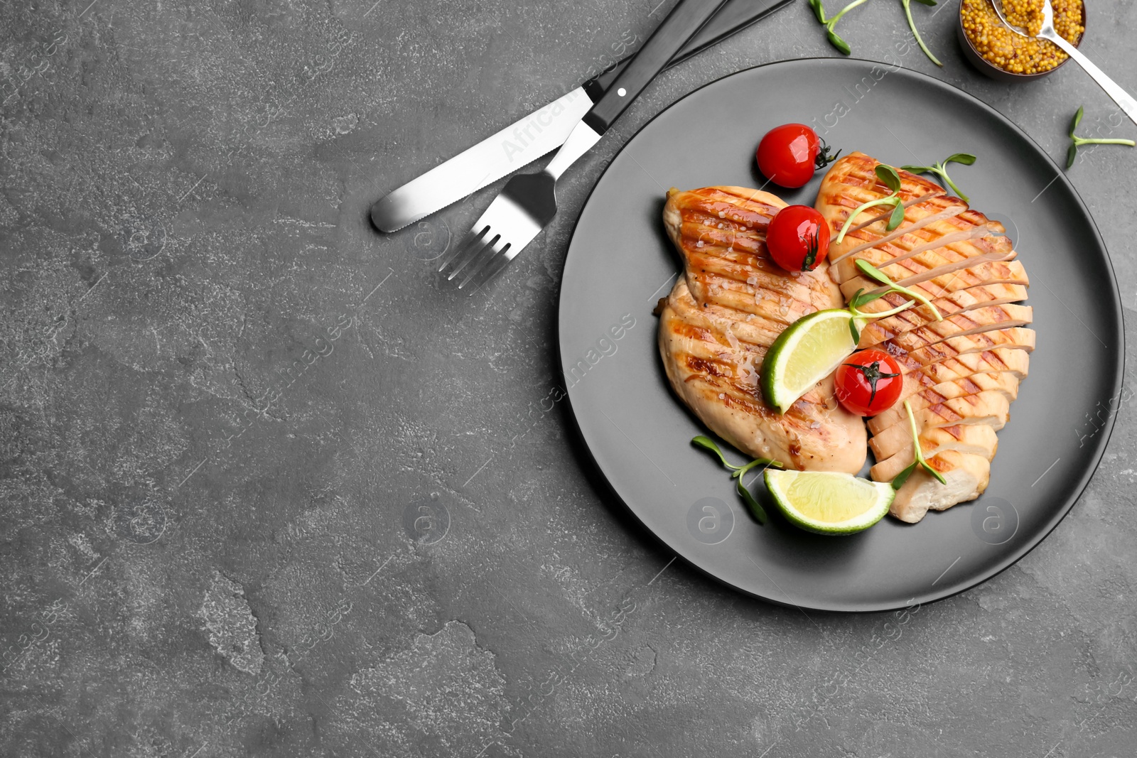 Photo of Tasty grilled chicken fillets served on grey table, flat lay. Space for text