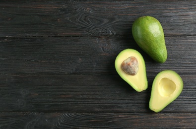 Tasty ripe green avocados on wooden background, top view