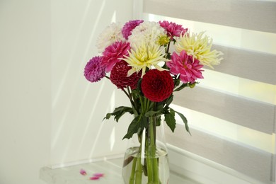 Photo of Bouquet of beautiful Dahlia flowers in vase on windowsill indoors