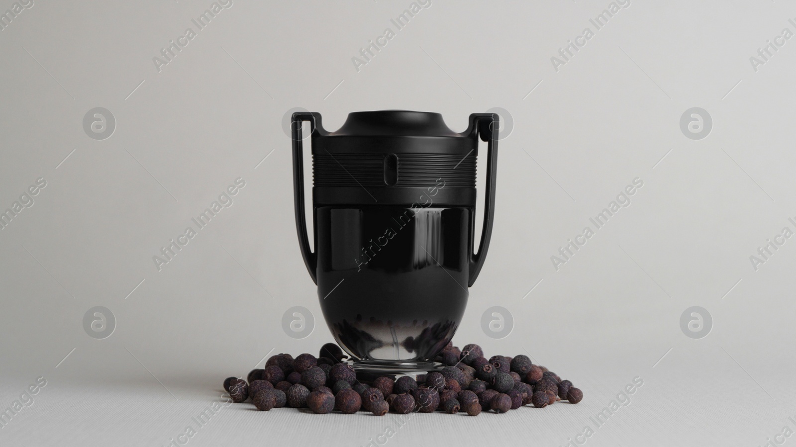 Photo of Bottle of luxurious perfume and spice on light grey background