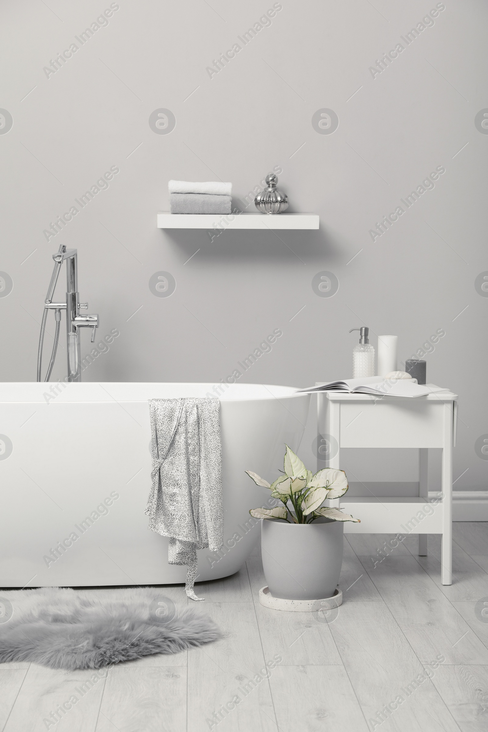 Photo of White tub and beautiful plant in bathroom, Interior design