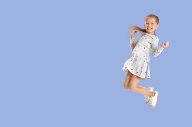 Image of Cute girl jumping on light blue background, space for text